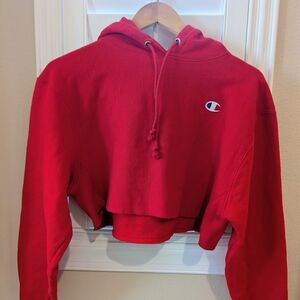 Champion Women's Reverse Weave Cropped Cut-Off Hooded Sweatshirt in Red. 